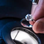 A brilliant cut diamond engagement ring being clarity graded under the microscope