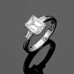 A beautiful platinum, emerald cut diamond ring with tapered baguette cut diamonds to the shoulders. 
