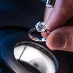 A mounted brilliant cut diamond being examined under the microscope, in this instance using both darkfield and incident lighting.