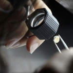 A brilliant cut diamond receiving a preliminary examination prior to grading for the 4Cs