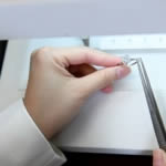 Trang examining a diamond ring under strictly controlled lighting in her laboratory.